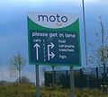 Direction sign saying 'please get in lane'.